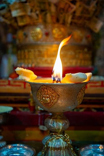 Tibet, Kham, Litang. A candle burns at the altar of a Litang Monastery. Religious Print